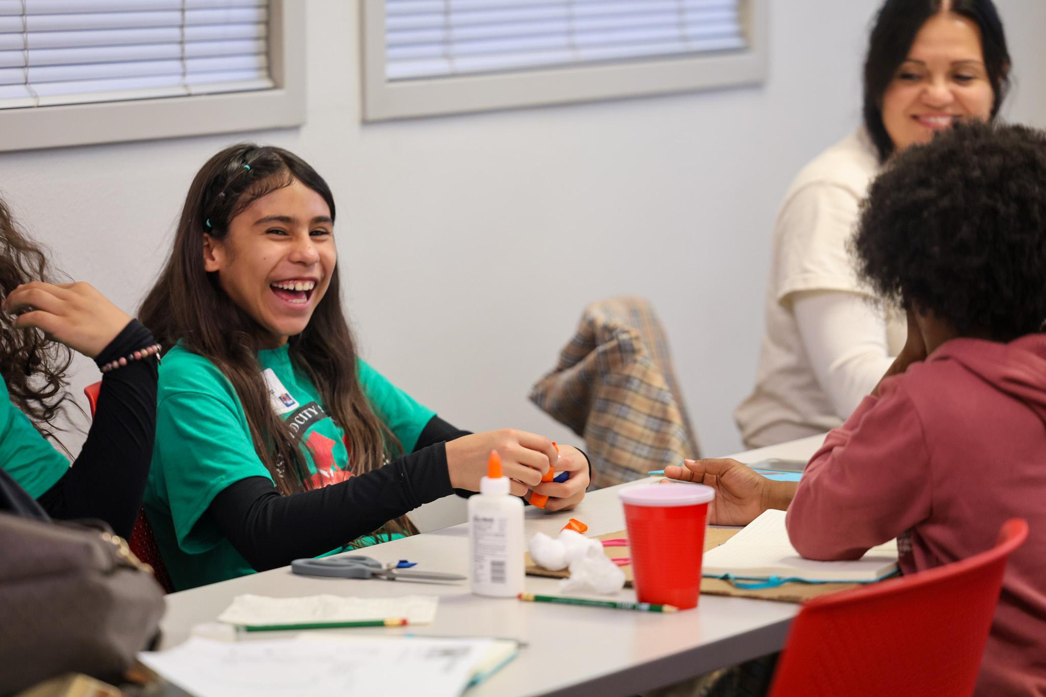 Student smiling as she participates in hands-on activity at event