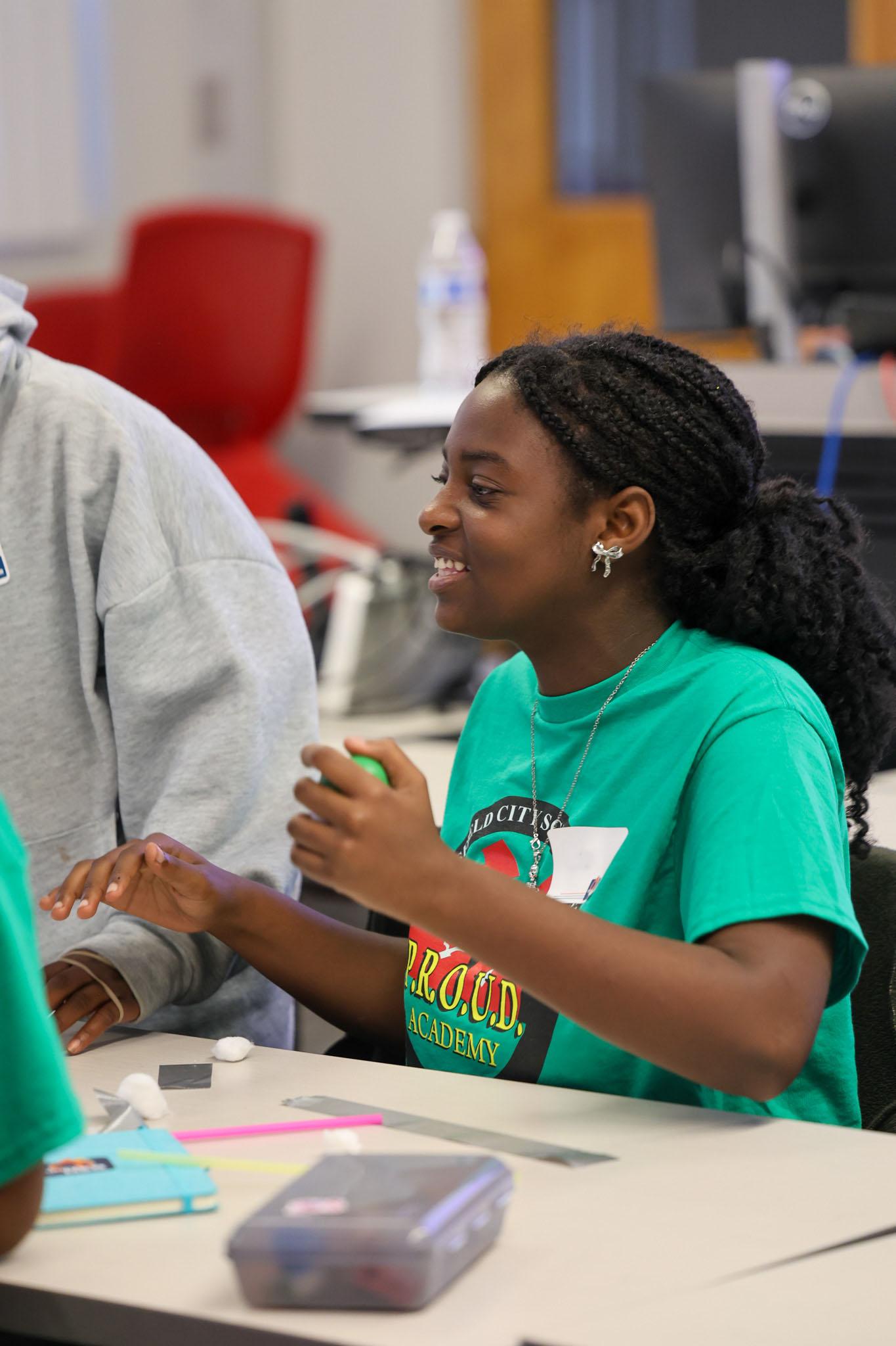 Student smiling with materials in her hand