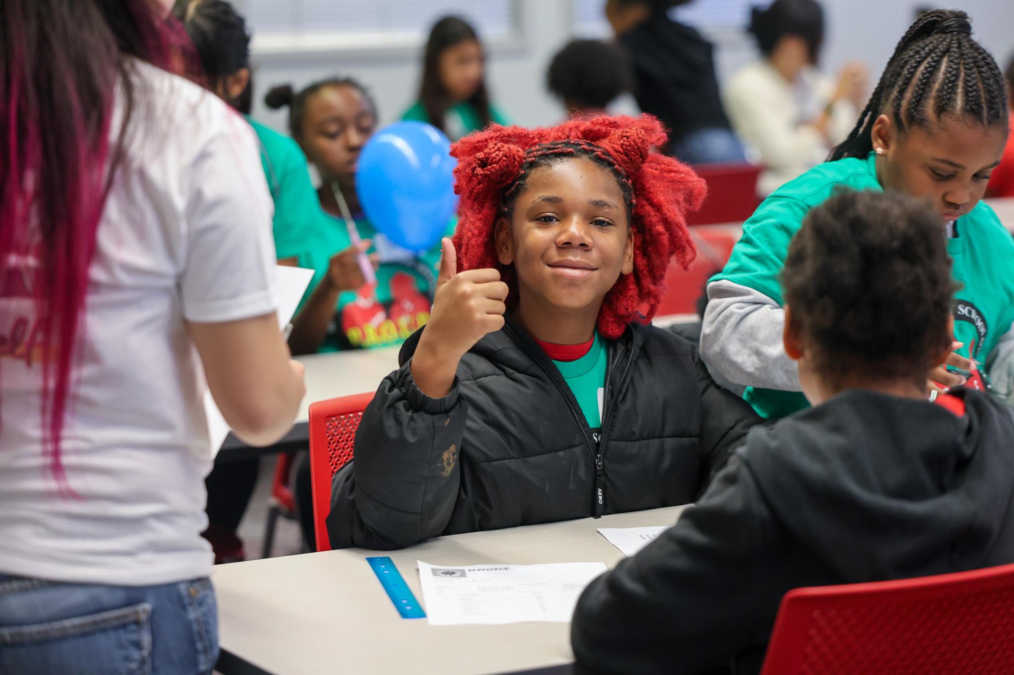 Student giving thumbs up to camera
